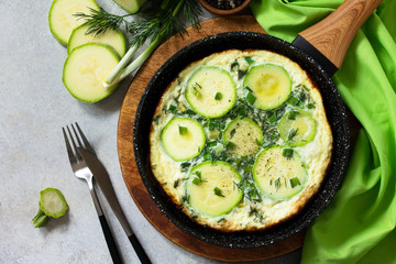 Breakfast. Summer omelet with zucchini and herbs on a stone or slate table. Top view flat lay. Copy space.