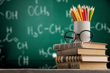 Stack of vintage books and colorful pencils on the desk
