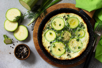 Breakfast. Summer omelet with zucchini and herbs on a stone or slate table. Top view flat lay.