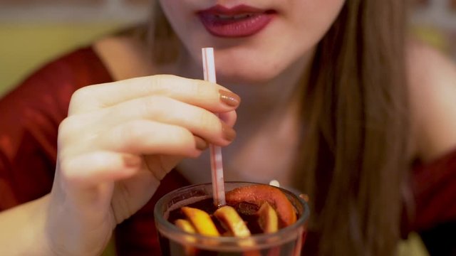 A Woman Drinks An Alcoholic Cocktail. Close- up of a Girl's Mouth and a Cocktail Tube