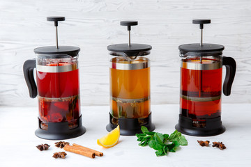 Glass teapots with several types of tea on a light background. Ads for cafe menus. Coffee shop menu. Horizontal photo.