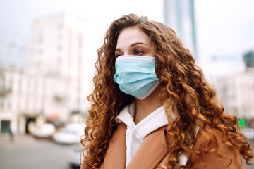 Girl in protective sterile medical mask on her face on the street. Woman, wear face mask, protect...