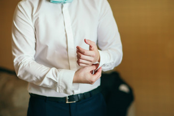 The groom in the morning preparing for the wedding and dresses