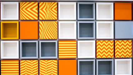  Wall shelves background. square book shelves. decorative cubic, square shelves. yellow-orange stripes. Bright, rich colors. © Vitali