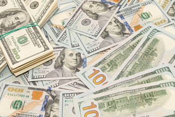 Many hundred dollar bills on wooden table background texture. bundles of money scattered on the office desk. wealth and income concept