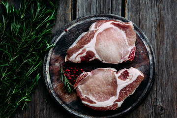 Raw meat on a cutting board on the kitchen table. Pork steak. Country style.