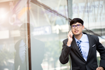 Young businessman running while talking on the mobile phone during rush hour. Business rushing concept.