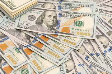 Many hundred dollar bills on wooden table background texture. bundles of money scattered on the office desk. wealth and income concept