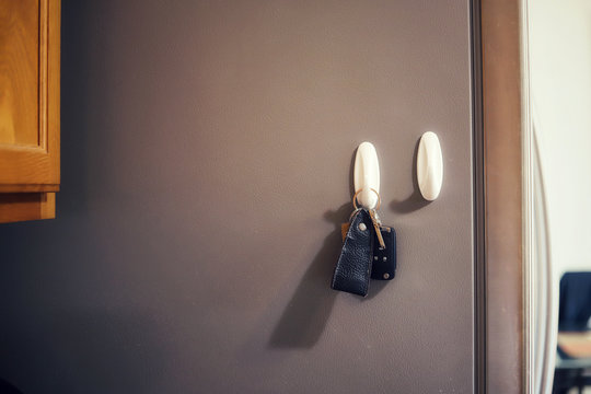 A Set Of Car Keys On A Hook Attached To A Fridge