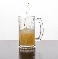 Beer is poured into a glass glass on a white background.