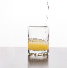 Beer is poured into a glass glass on a white background.