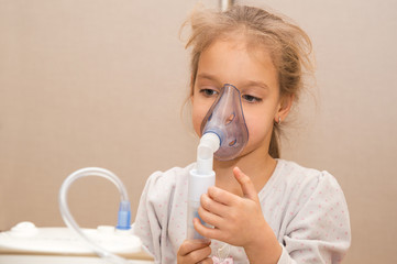 Close up. Respiratory diseases. A 5-year-old child inhales medication using a nebulizer. Therapy of coronavirus, broncho tracheitis, asthma. Copy space.