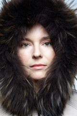 Portrait of a young female in a winter coat with fur trimmed hood.