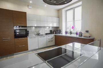 View of luxury modern fitted kitchen with stainless steel appliances