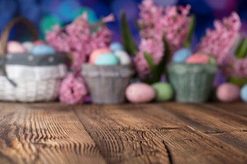 Easter background. Rustic wooden table. Tulips and spring flowers. Easter eggs. Pastel colors bokeh. 