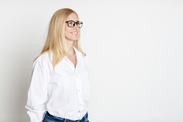 Indoor portrait of beautiful blonde in glasses smiling