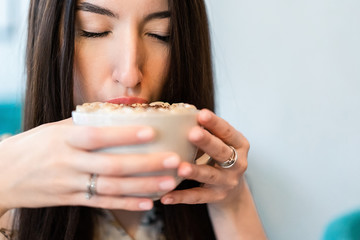 girl in a cafe at a table with coffee and a notebook