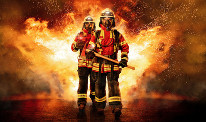 Fototapeta Zwei Feuerwehrmänner unter Atemschutz gehen durchs Feuer obraz