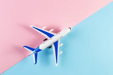 Model plane, airplane on a pink and blue background. Summer travel or vacation concept. Flat lay of miniature toy airplane. trendy minimal style, copy space