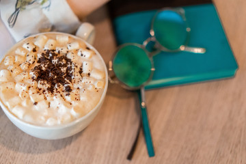 cup of coffee in girl hand on the table