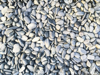 Closeup on white grey rocks and pebbles stone pattern and texture backdround.