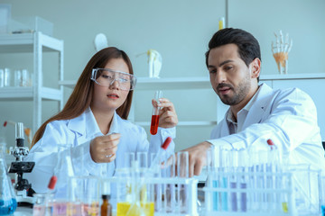 Attractive scientist medical team worker with sample test tube at laboratory , doing a analysis in a laboratory doing research and development
