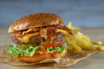Burger with bacon, cheese and fried potatoes