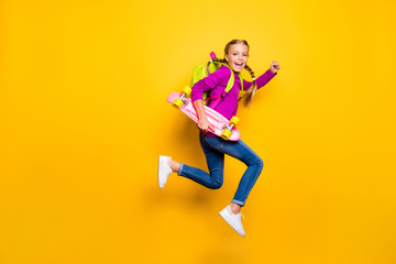Fototapeta na wymiar Full length body size view of her she nice attractive lovely glad cheerful cheery girl jumping running carrying skateboard isolated over bright vivid shine vibrant yellow color background