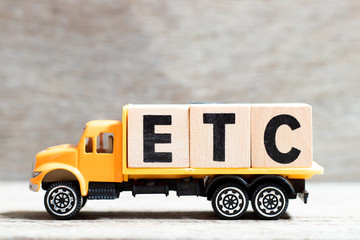 Truck hold letter block in word etc (abbreviation of et cetera) on wood background