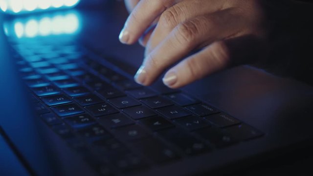 close up of hands of business person or gamer working on computer, man using internet and social media blue neon light