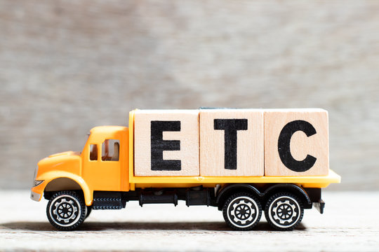 Truck hold letter block in word etc (abbreviation of et cetera) on wood background