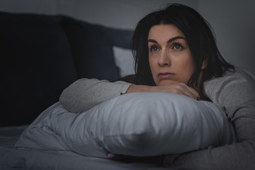 Fototapeta premium selective focus of dissatisfied woman having insomnia while lying on bed at night