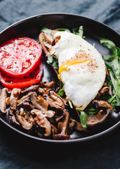 Sandwich with fresh arugula, fried shiitake mushroom, shallot onion, egg served with tomatoes.