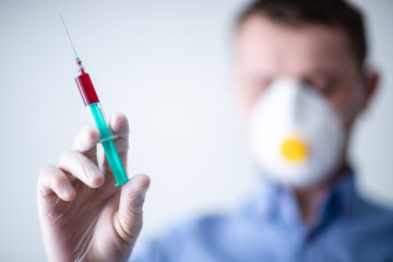 Doktor tzrymający w dłoni szczepionkę na Coronavirus, COVID-19, maska bezpieczeństwa