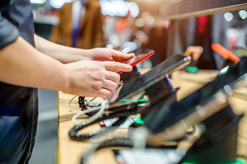 Girl chooses a mobile phone in the store