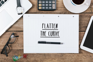 Flatten the curve written in notepad on table, pencil for writing, grunge office deskt flat lay...