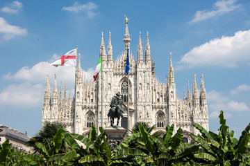 Obraz premium Duomo di milano blue sky european flags trees in front
