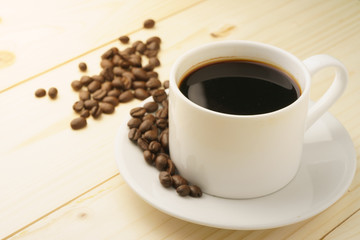 coffee cup with coffee beans on wooden table. free copy space for your text