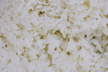 Boiled rice with soy or wine sauce for making sushi as background , close up