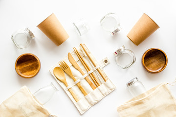 Zero waste set with recycled tableware, cotton bag, glass jars on white desk, top view. Plastic free, eco friendly concept