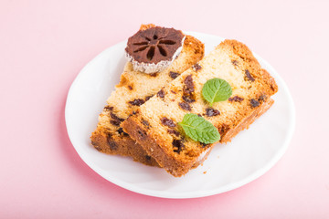 Homemade cake with raisins and dried persimmon on a pink pastel background. Side view, copy space.