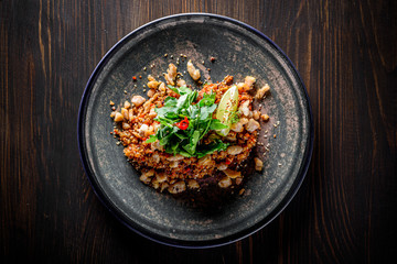 Fried rice with chicken and vegetables in plate on wooden table background
