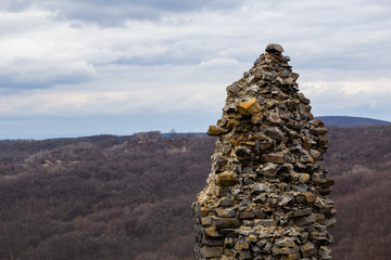 Part of the unrestored medieval ruins of Somoskő Castle, with autumn landscape in the background.