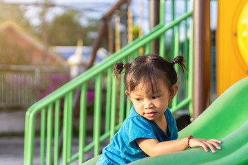 Fototapeta na wymiar Portrait image of 1-2 yeas old baby. Happy Asian child girl smiling and laughing. She playing with slider bar toy at the playground. Learning and active of kids concept.