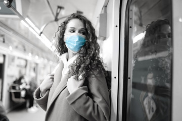 Black and white foto of girl in protective sterile medical mask on the subway. Woman, wear face mask, protect from infection of virus, pandemic, outbreak and epidemic of disease in quarantine city. 
