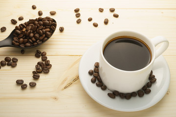 coffee cup with coffee beans on wooden table. free copy space for your text