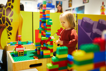 girl playing with colorful plastic construction blocks