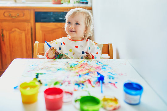 Adorable little girl painting with fingers