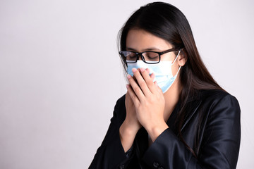 Close up of a businesswoman in a suit wearing Protective face mask and cough, get ready for Coronavirus and pm 2.5 fighting against on gray background.