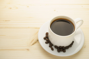coffee cup with coffee beans on wooden table. free copy space for your text